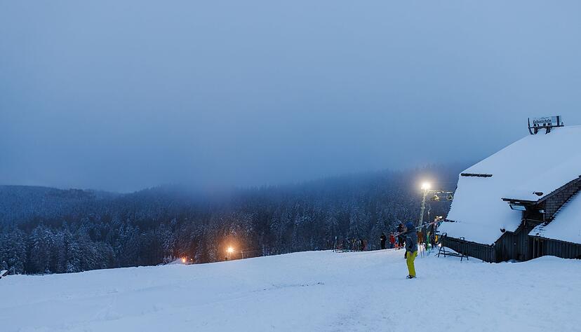 Ein Wintersportler steht am Freitag vor dem nebelverhangenen Schwarzwald.
