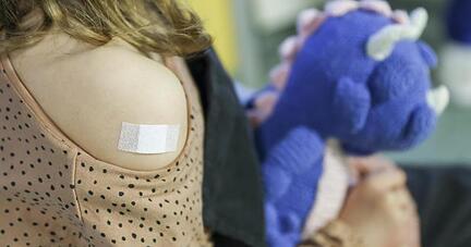 Ein Pflaster klebt auf den Arm eines Mädchens, nachdem es gegen Corona geimpft wurde. Ein Pflaster klebt auf den Arm eines Mädchens, nachdem es gegen Corona geimpft wurde.