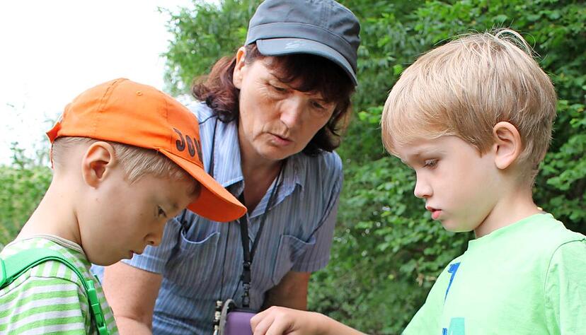 Kindergartenleiterin Margarete K&uuml;hn (Mitte) mit ihren Sch&uuml;tzlingen aus dem Kindergarten Westernach. Der f&uuml;nfj&auml;hrige Jonathan (links) h&auml;lt einen Stein, auf dem sich ein Tier befindet, das in die Becherlupe soll. Fotos: Juliane Renk