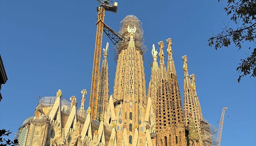 Noch verdecken ein Baugerüst und ein großer gelber Kran die Spitze des Hauptturms der Sagrada Familia.