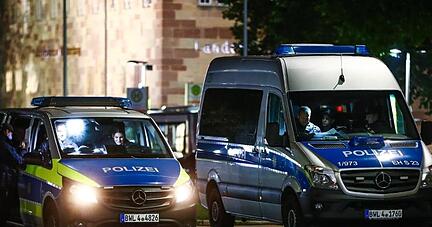Polizei-Einsatzwagen stehen auf dem Schlossplatz, um die Einhaltung der Corona-Regeln zu kontrollieren.