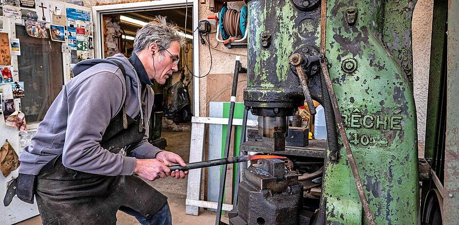 Von der Esse zum Lufthammer: Martial Herbst muss zum Schmieden das mehrere hundert Grad hei&szlig;e Material ausziehen. Das geschieht mit der Kraft des Kolben, dem B&auml;r, und der Schlaggeschwindigkeit.