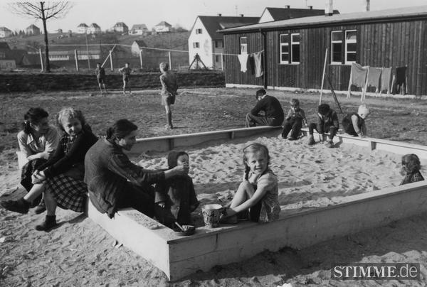 1953 - Für die jüngsten Bewohner ist nach den Strapazen der Vertreibung und Flucht das Spielen im Sandkasten eine Rückkehr in die Kindheit. 1953 - Für die jüngsten Bewohner ist nach den Strapazen der Vertreibung und Flucht das Spielen im Sandkasten eine Rückkehr in die Kindheit.