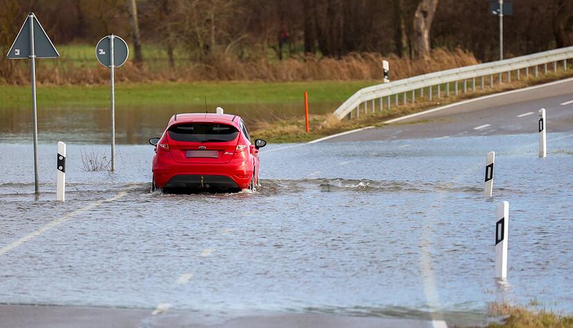 Ein Auto fährt auf einer mit Hochwasser überfluteten Straße zwischen Daugendorf und Unlingen. Ein Auto fährt auf einer mit Hochwasser überfluteten Straße zwischen Daugendorf und Unlingen.