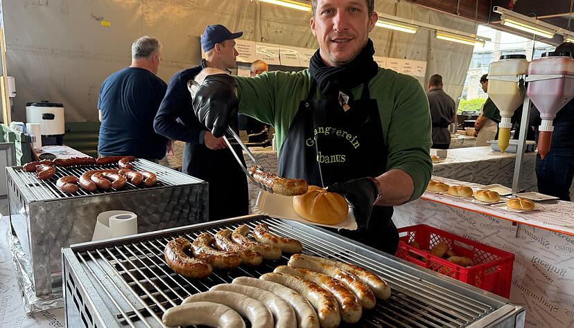 Elias Link vom Lauffener Gesangverein Urbanus gibt die exklusiv hergestellte Schwarzriesling-Wurst an die Festg&auml;ste heraus.