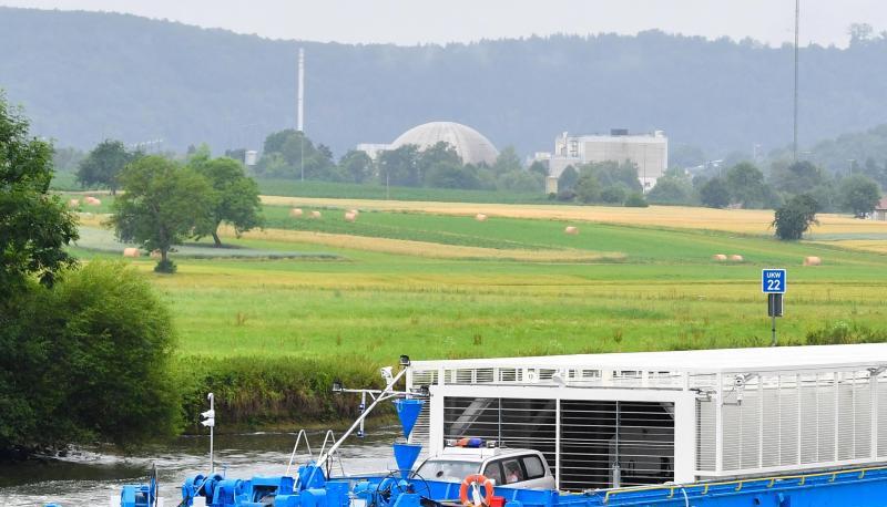 Mit Castoren beladenes Transportschiff auf dem Neckar vor einem Atomkraftwerk. Foto: Uwe Anspach/Archiv