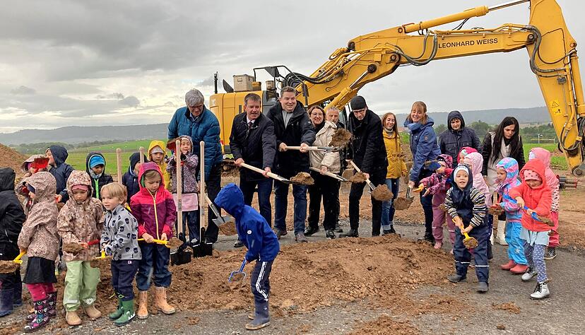 Die Kindergartenkinder vom Limespark greifen zusammen mit den Erwachsenen zu den Spaten, um mit dem Bau ihrer Grundschule zu beginnen.