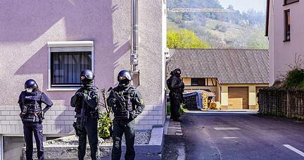 Bewaffnete Polizisten umziegeln das Haus eines mutmaßlichen Reichsbürgers in Boxberg (Main-Tauber-Kreis).