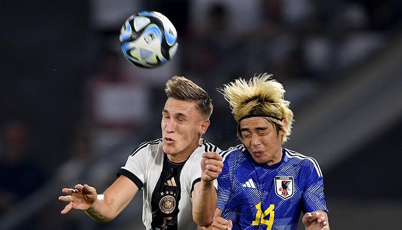 Nico Schlotterbeck (l) und Japans Junya Ito beim Kopfballduell.