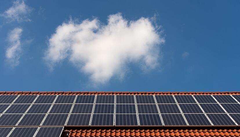 Solarzellen liegen auf einem Ziegeldach.