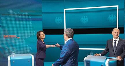 Die Kanzlerkandidaten Armin Laschet (mitte, CDU), Annalena Baerbock (l., Bündnis 90/Die Grünen) und Olaf Scholz (SPD) begrüßen sich vor der Sendung im Fernseh-Studio in Berlin-Adlershof.
