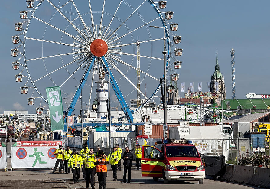 Mit Durchsagen werden Wiesnbesucher vor dem abgesperrten Oktoberfestgelände auf eine mögliche Gefahrenlage hingewiesen. Denn am Mittwochmorgen soll es eine Bombendrohung gegeben haben.