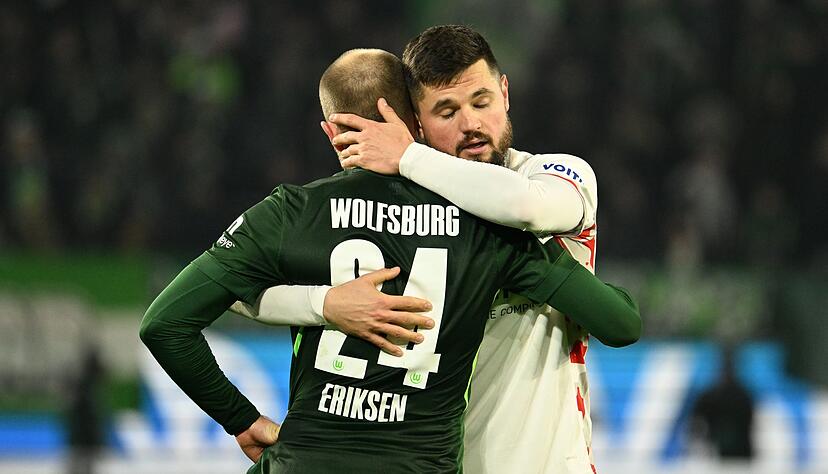 Heidenheims Marnon Busch umarmt Wolfsburg-Star Christian Eriksen.