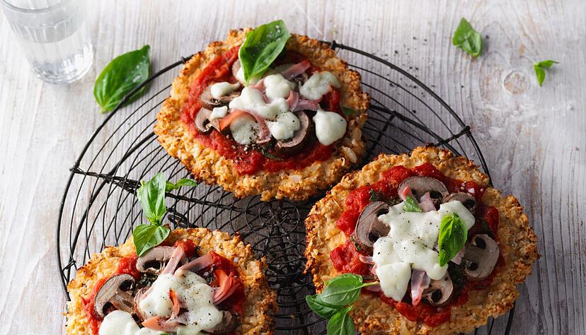 Pizzateig geht auch mit Blumenkohl. Dafür schreddert man ihn zunächst auf Reiskorngröße, ehe man ihn mit Ei, geriebenem Käse und Mandelmehl zu einem Teig vermengt.