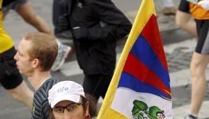 Ein Läufer trägt beim Marathon in Paris eine Tibet-Fahne.