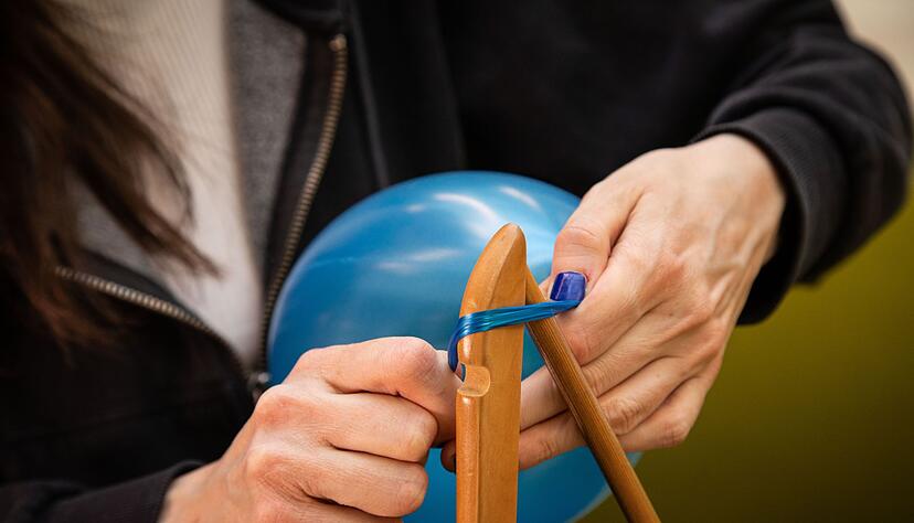 Schritt 1: Den Hals des Luftballons um ein Ende des Kleiderb&uuml;gels wickeln.
