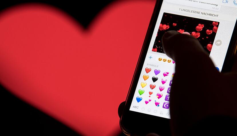 Hand aufs Handy - das rote Herz zählt zu den beliebtesten Emojis. (Archivbild) Hand aufs Handy - das rote Herz zählt zu den beliebtesten Emojis. (Archivbild)