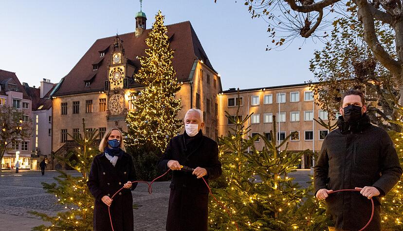 Vor dem Rathaus illuminieren OB Harry Mergel, Axel Palm von der Stadtinitiative (rechts) und City-Managerin Irina Guzina am Donnerstagabend die Weihnachtsbeleuchtung in der Innenstadt.
