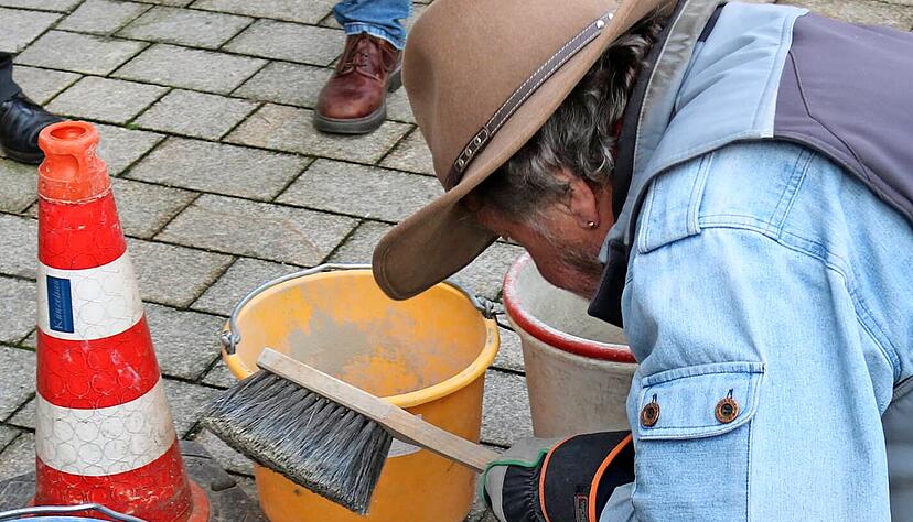 Nur wenige Minuten braucht Gunter Demnig für das Verlegen der einzelnen Steine. Die Stadt hatte bereits vergangene Woche die Löcher vorbereitet.