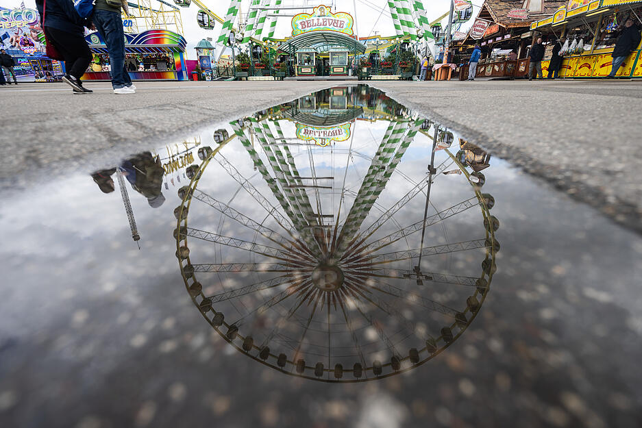 Ein Riesenrad spiegelt sich in einer Pfütze auf dem Festgelände. Das Wetter am ersten Festwochenende ist alles andere als frühlingshaft. Ein Riesenrad spiegelt sich in einer Pfütze auf dem Festgelände. Das Wetter am ersten Festwochenende ist alles andere als frühlingshaft.