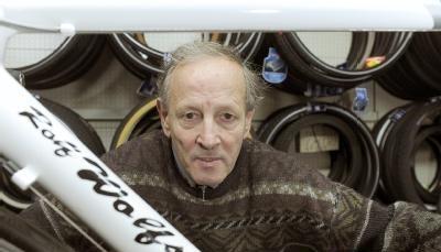 Rolf Wolfshohl h&auml;lt in seinem Gesch&auml;ft in K&ouml;ln ein Rennrad aus seiner eigenen Kollektion.