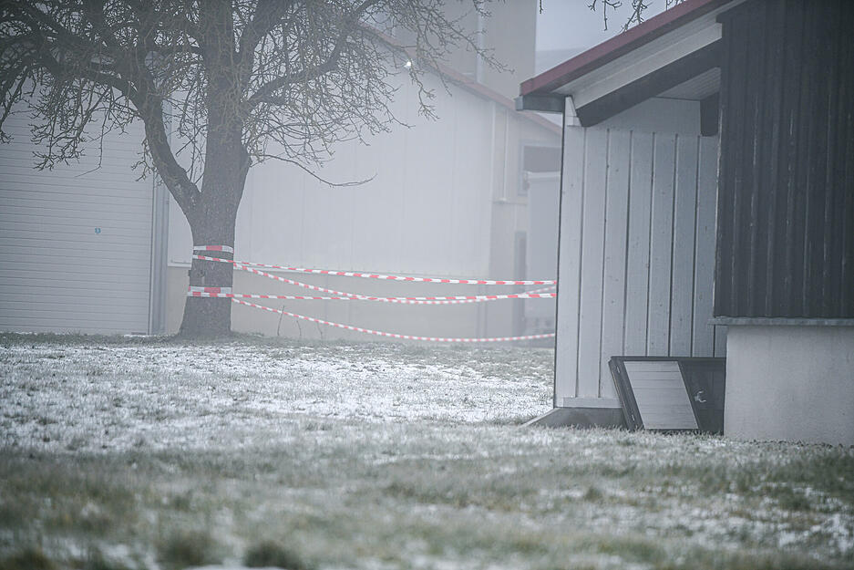 Vogelgrippe-Ausbruch im Landkreis Schwäbisch Hall: Rot-weißes Flatterband sperrt den Durchgang an einer Halle auf einem Hof mit Putenmast.