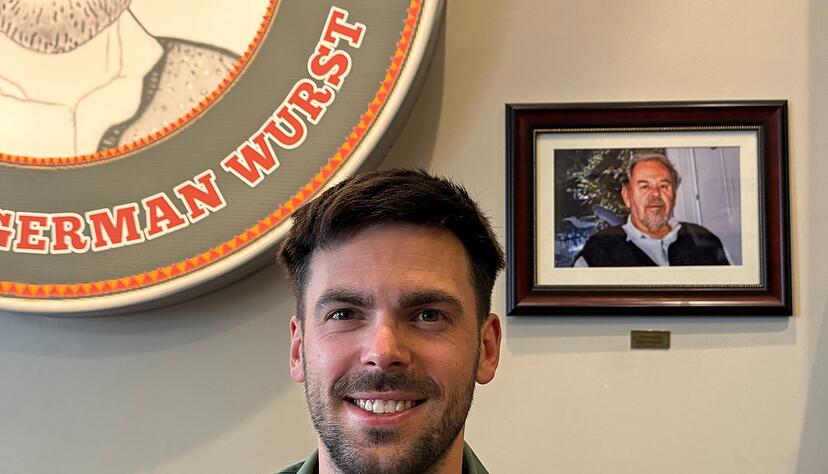 Fabian F&ouml;rster steht vor einem Foto seines Gro&szlig;vaters, nach dem &laquo;Dieters Grill&raquo; benannt wurde.