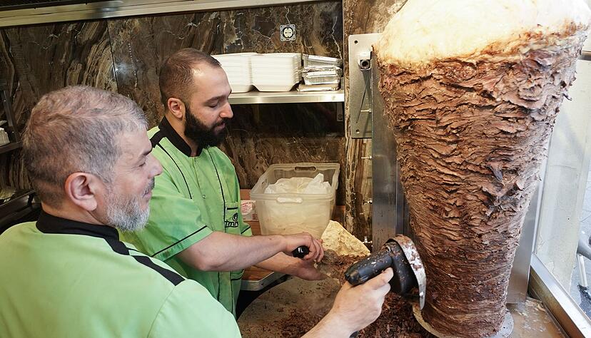 Halit (l) und Halip vom Imren Grill in Berlin bereiten einen D&ouml;ner zu. Vor f&uuml;nfzig Jahren soll er erfunden worden sein.