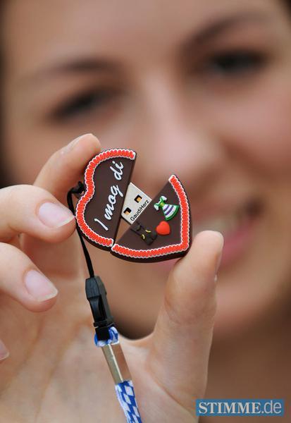 Die Praktikantin im Referat für Arbeit und Wirtschaft, Stefanie, hält am 25.07.2013 während einer Pressekonferenz zum Oktoberfest 2013 in München (Bayern) einen USB-Stick in der Form eines Lebkuchenherzes in Händen. Foto: Andreas Gebert/dpa +++(c) dpa - Bildfunk+++