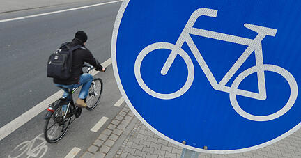 Ein Mann fährt am 18.02.2015 in Mörfelden-Walldorf (Hessen) mit seinem Fahrrad auf einem mit einem Verkehrsschild gekennzeichneten Radweg. Radler freuen sich, wenn sie so ein blaues Schild sehen. Denn auf Radwegen fährt es sich sicherer. Foto: Arne Dedert/dpa ACHTUNG: Dieses Bild hat dpa auch im Bildfunk gesendet. +++(c) dpa - Nachrichten für Kinder+++ | Verwendung weltweit