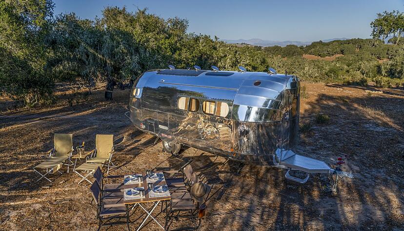 Amerikanisches Idyll: Der luxuriöse E-Caravan Bowlus Volterra wurde an einem lauschigem Plätzchen aufgestellt - der Champus ist schon kaltgestellt.