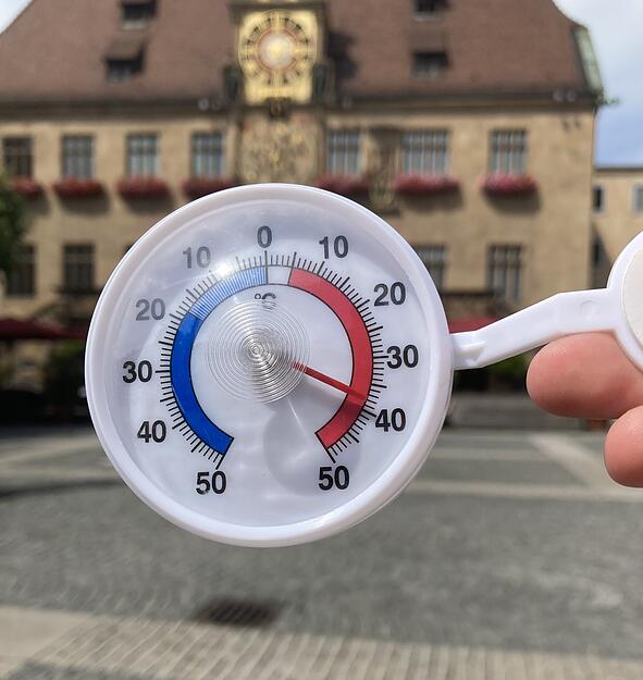 Raus aus der Kilianskirche. Nur wenige Meter weiter auf dem Marktplatz vor dem Heilbronnner Rathaus ist kein Schatten in Sicht. Das macht sich auf dem Thermometer bemerkbar: knapp 40 Grad zeigt es an.