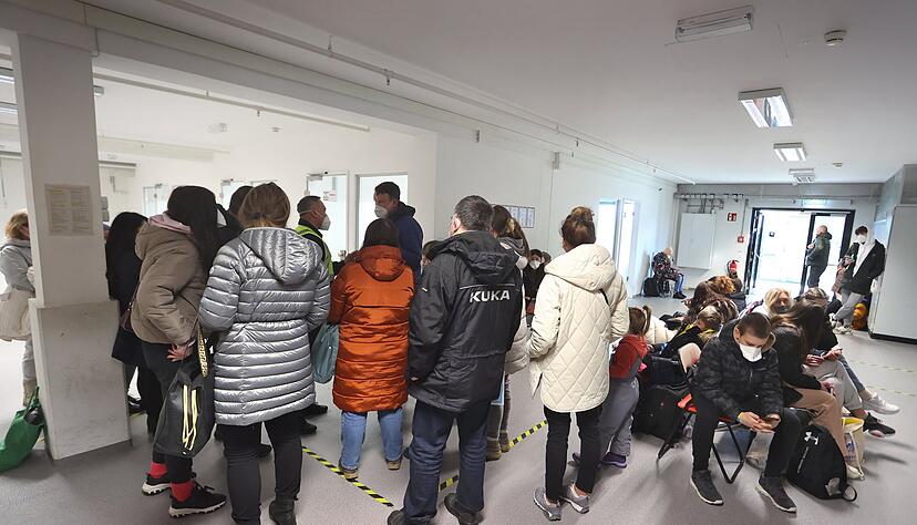 Nicht nur wie hier in Augsburg stehen Geflüchtete Schlange, um sich anzumelden. Die Registrierung ist eine bürokratische Herausforderung.