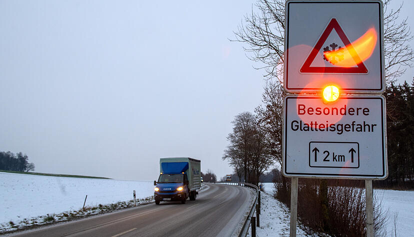 Ein Straßenschild warnt mit einer Blinkleuchte vor Glatteis. Für Montagnachmittag wird in Baden-Württember vor Eisregen gewarnt.