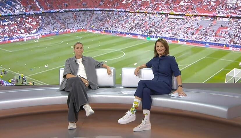 ZDF-Moderatorin Katrin Müller-Hohenstein (r.) trägt vor dem EM-Eröffnungsspiel kuriose Socken. ZDF-Moderatorin Katrin Müller-Hohenstein (r.) trägt vor dem EM-Eröffnungsspiel kuriose Socken.