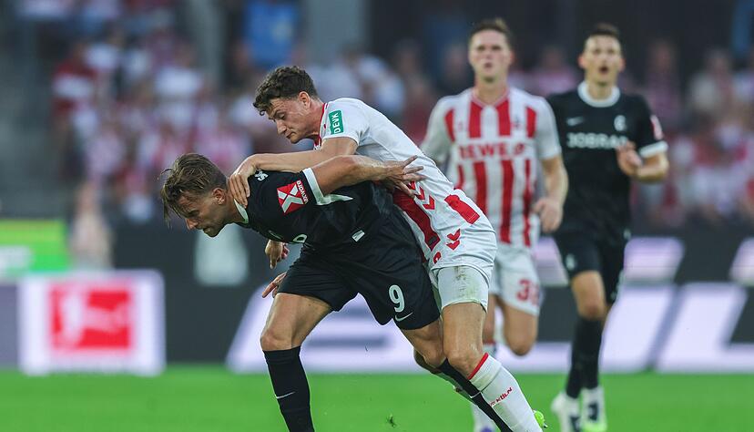Freiburgs Lucas Höler (l) und Kölns Eric Martel kämpfen um den Ball.