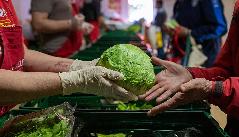 In einer Ausgabestelle verteilt eine ehrenamtliche Mitarbeiterin einen Eisberg Salat. Angesichts steigender Lebensmittelpreise, höherer Energiekosten und des Ukraine-Kriegs stehen Tafeln bundesweit immer mehr unter Druck. In einer Ausgabestelle verteilt eine ehrenamtliche Mitarbeiterin einen Eisberg Salat. Angesichts steigender Lebensmittelpreise, höherer Energiekosten und des Ukraine-Kriegs stehen Tafeln bundesweit immer mehr unter Druck.
