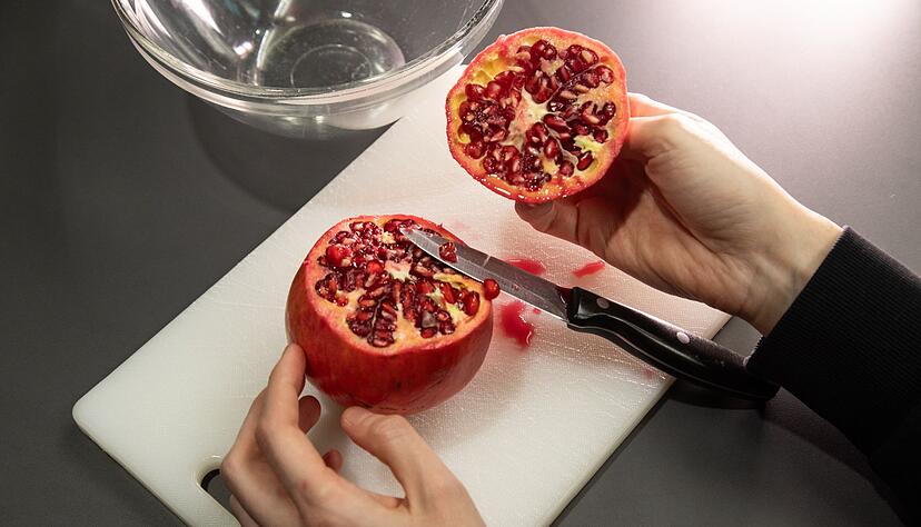 Schritt 1: Die obere Kappe des Granatapfels abschneiden und den Deckel abnehmen. Schritt 1: Die obere Kappe des Granatapfels abschneiden und den Deckel abnehmen.