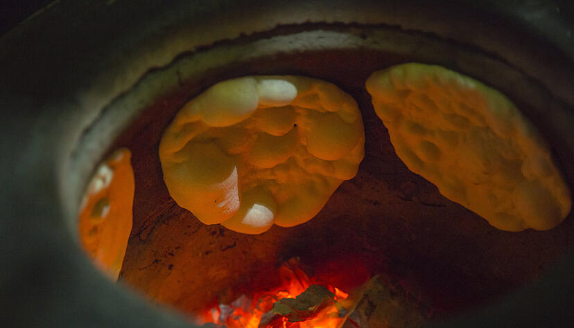 Klassische Naan-Brot-Zubereitung erfolgt im Tandoori-Ofen (Tonofen). Es klappt aber auch mit einer heißen Pfanne oder über dem Lagerfeuer. Foto:  Kampol/stock.adobe.com