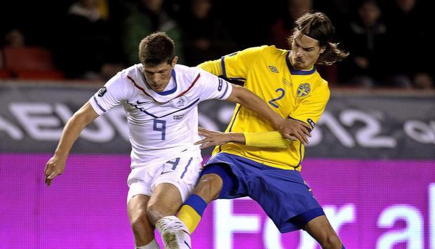 Der Niederl&auml;nder Klaas-Jan Huntelaar (v) behauptet sich gegen den Schweden Mikael Lustig. Foto: Anders Wiklund.