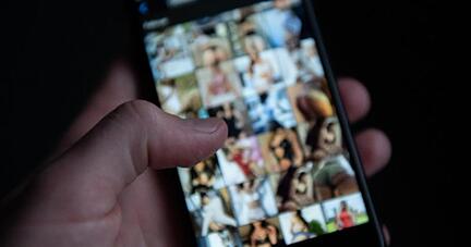 Ein Mann schaut sich auf einem Smartphone pornografische Bilder an. Polizei und Staatsanwaltschaft sind mit einer bundesweiten Razzia gegen 65 Verdächtige vorgegangen, die kinderpornografische Inhalte besessen und verbreitet haben sollen.