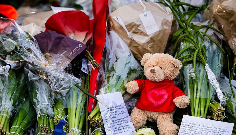 Menschen legen Blumen, Teddys und Botschaften am Brandort ab. Menschen legen Blumen, Teddys und Botschaften am Brandort ab.