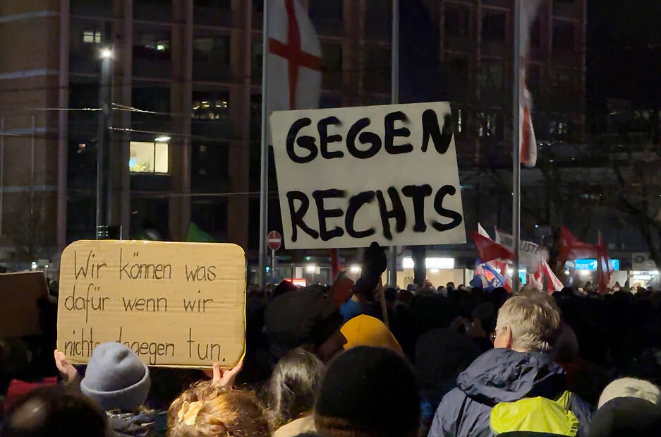 Auf dem Platz der alten Synagoge halten Menschen Schilder mit der Aufschrift "Gegen Rechts" und "Wir können was dafür, wenn wir nichts dagegen tun" hoch. Auf dem Platz der alten Synagoge halten Menschen Schilder mit der Aufschrift "Gegen Rechts" und "Wir können was dafür, wenn wir nichts dagegen tun" hoch.
