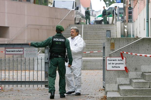 Ein Mitarbeiter der Spurensicherung (rechts) läuft am Freitag über das Gelände des Carolinum-Gymnasiums.