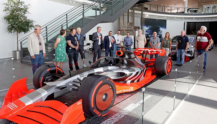 Neckarsulms Werkleiter Fred Schulze (Mitte mit Mikrofon) hat den Teilnehmern auch das Formel 1-Showcar gezeigt und viel zum Standort erzählt.