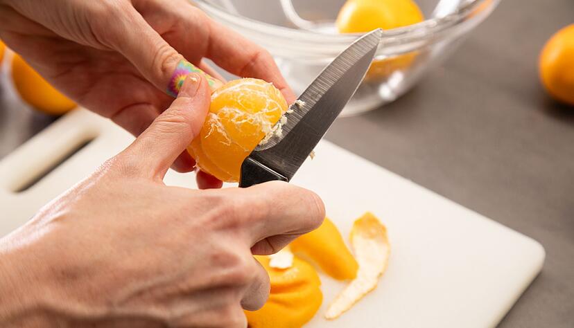 Schritt 3: Clementine mit einem Messer von den weißen Fäden befreien.