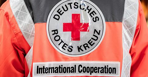 Mitarbeiter des Deutschen Roten Kreuzes treten immer in Dienstkleidung auf, wenn sie im Auftrag des DRK unterwegs sind. Dieses Foto zeigt einen Mitarbeiter der humanit&auml;ren Hilfe, der in einem Lager f&uuml;r internationale Hilfsg&uuml;ter arbeitet.