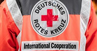 Mitarbeiter des Deutschen Roten Kreuzes treten immer in Dienstkleidung auf, wenn sie im Auftrag des DRK unterwegs sind. Dieses Foto zeigt einen Mitarbeiter der humanit&auml;ren Hilfe, der in einem Lager f&uuml;r internationale Hilfsg&uuml;ter arbeitet.