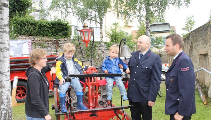 Christine Fritsche mit Janez (3), Beno (1) und Robert Kocevar sowie Feuerwehrkamerad Daniel Dietrich nehmen das Hydrophor von 1862 genauer unter die Lupe.