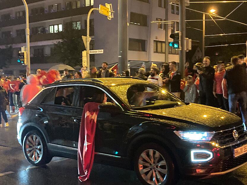 Aus den Autos beim Korso hängen Flaggen.